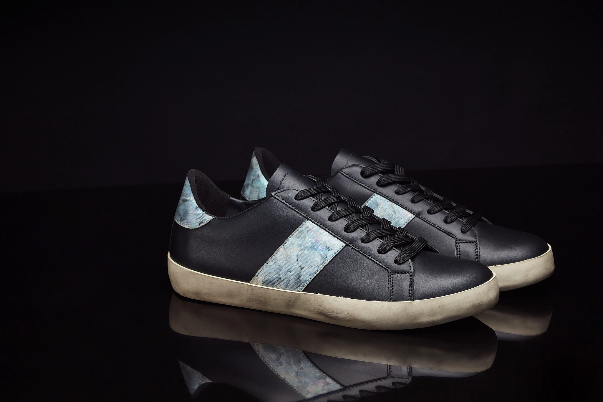 a pair of black mother of pearl shoes