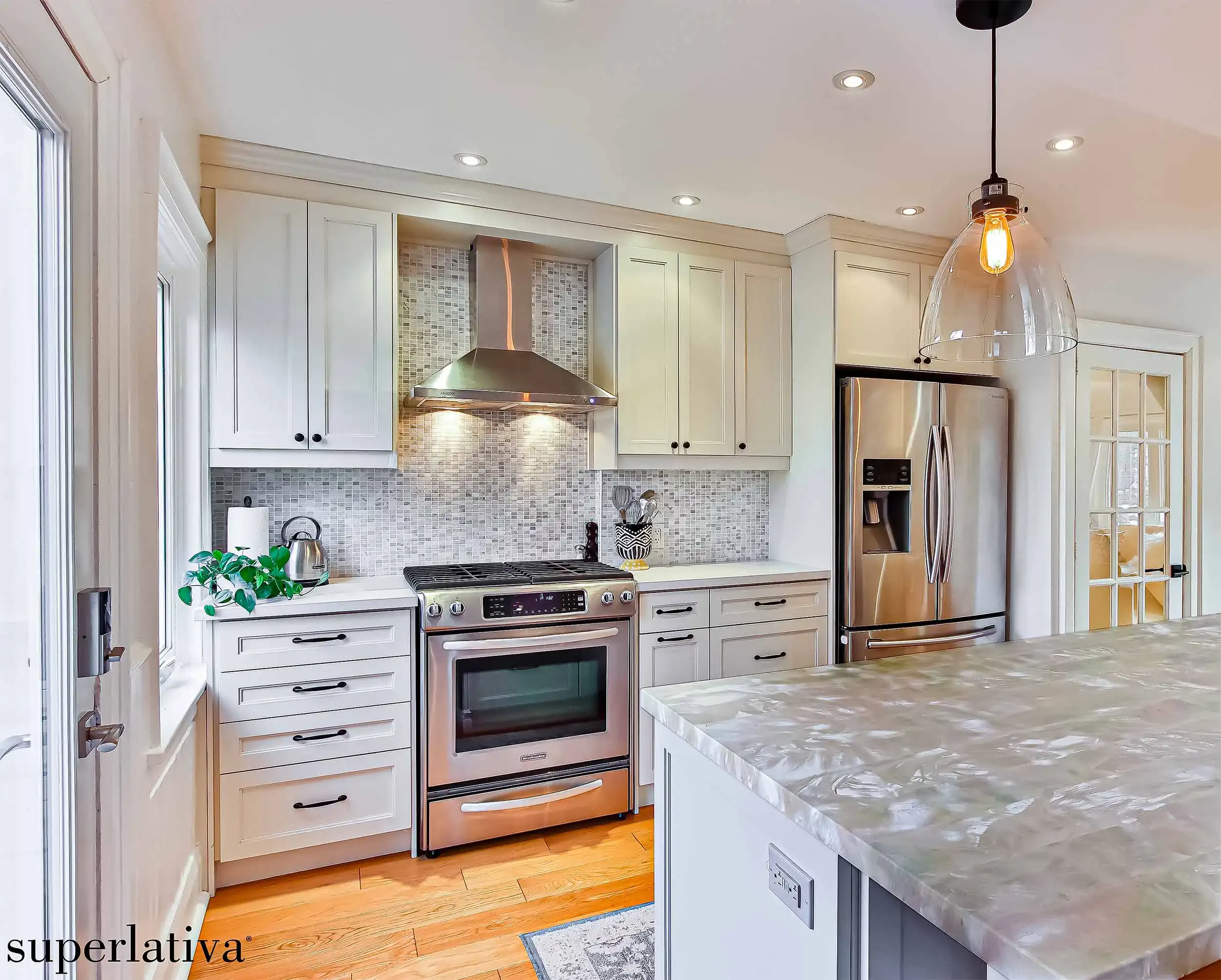 a kitchen with white cabinets and a mother of pearl marble countertop