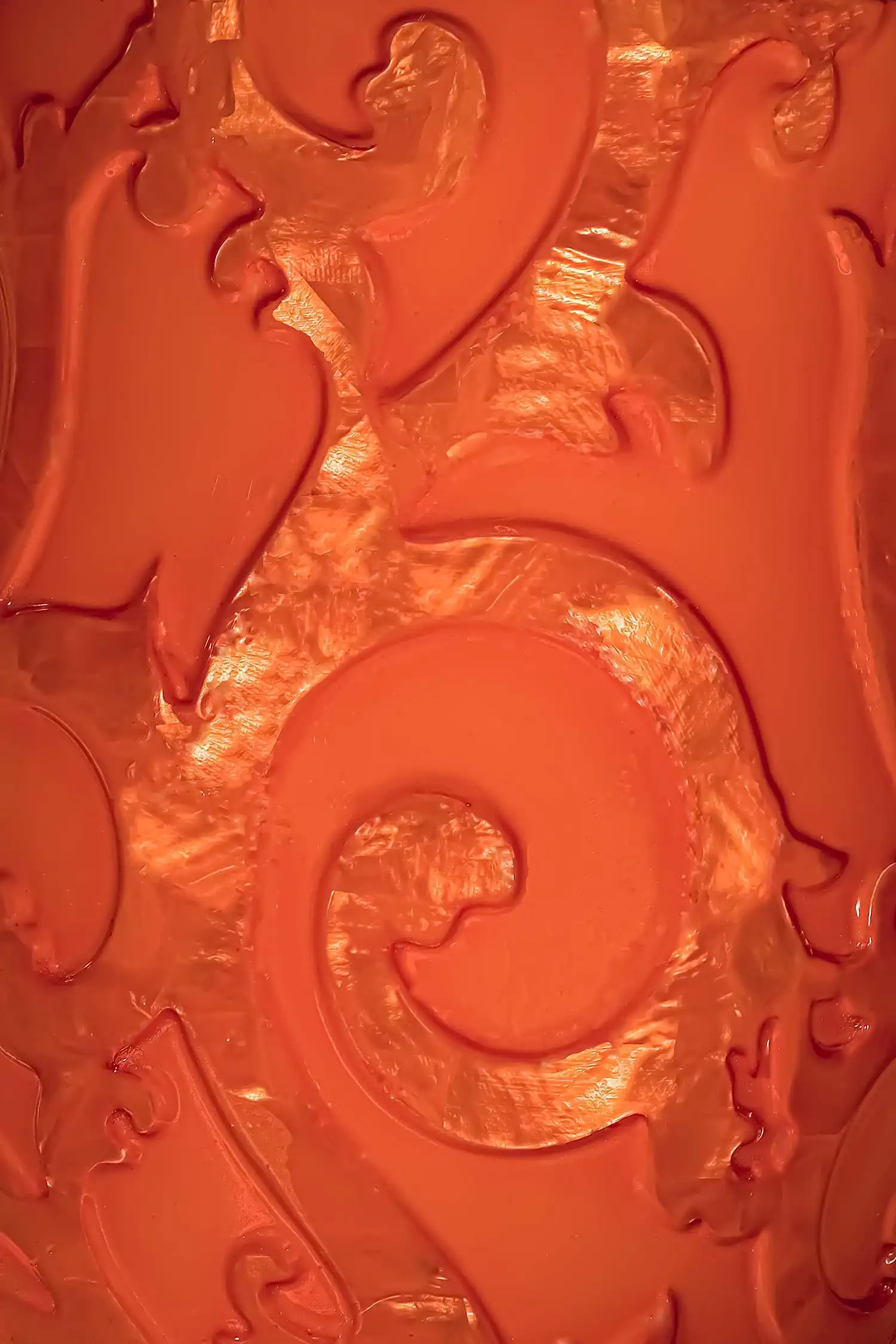 an orange vase with a swirl design
