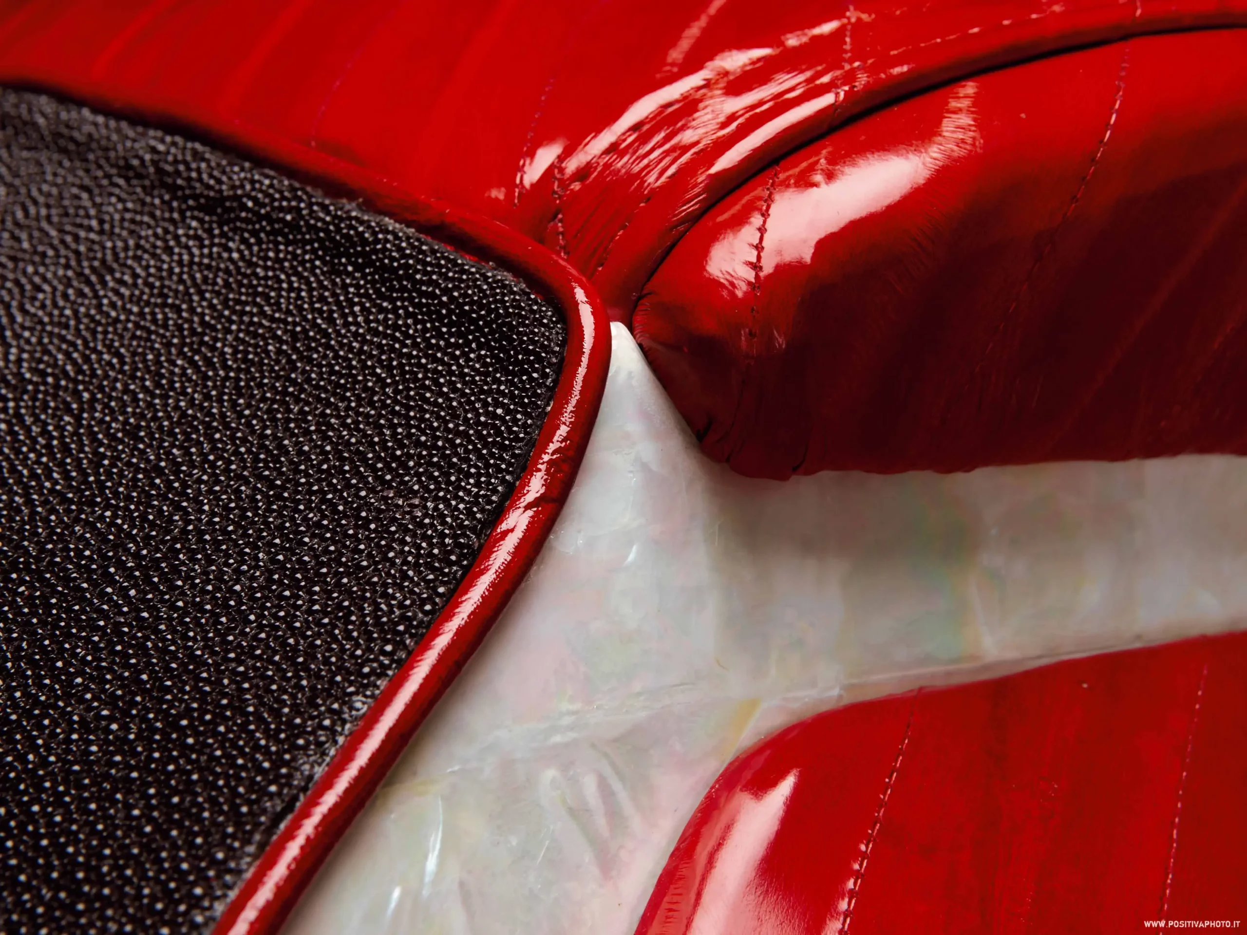 a close up of a red leather couch mother of pearl